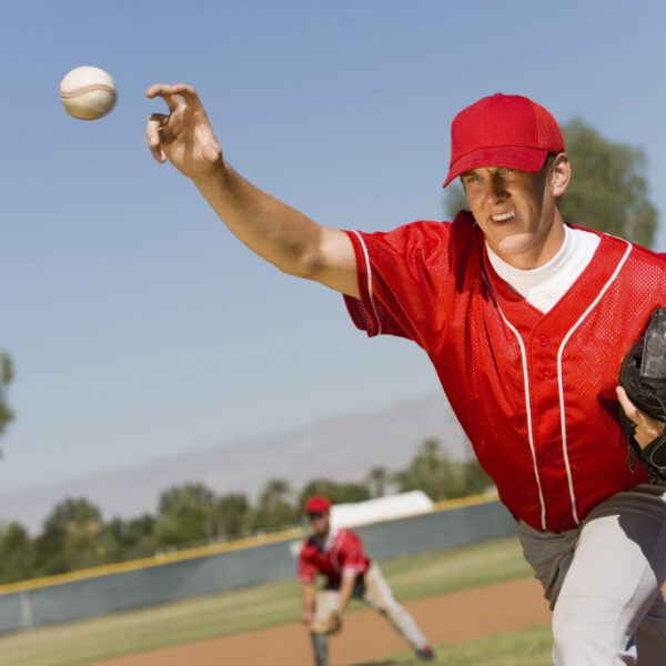 man playing baseball in red uniform